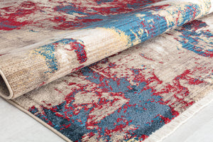 Folded abstract rug with vibrant red, blue, and beige colors.