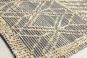 Close-up of geometric diamond pattern rug corner, showcasing detailed texture and craftsmanship.