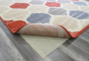 Geometric patterned rug corner lifted to show texture and non-slip pad.