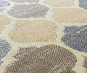 Abstract rug close-up showcasing beige, brown, and blue geometric patterns. Ideal for adding a modern and stylish touch to interiors.