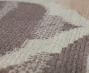 Close-up of the soft texture and detailed pattern of an abstract rug in beige and brown, ideal for adding comfort and style.