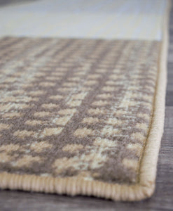 Close-up of modern abstract rug edge, showcasing durable stitching and intricate pattern in shades of brown and beige.