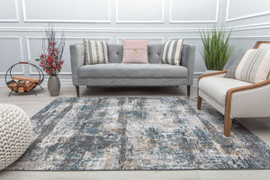 Living room with a modern sofa and abstract rug featuring distressed blue, white, and beige patterns, enhancing contemporary decor.