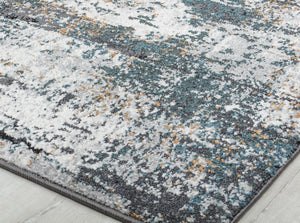 Detailed view of an abstract rug with distressed blue, white, and beige patterns, showcasing its modern and artistic design.