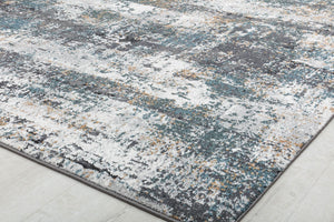 Close-up of an abstract rug with distressed blue, white, and beige patterns, ideal for modern home decor and adding a touch of artistry.