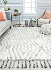 Modern living room with a white geometric patterned rug, cozy seating, and stylish decor elements creating a comfortable ambiance.