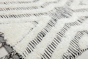 Close-up view of a white and black geometric pattern rug, highlighting its texture and design details