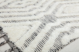 Close-up view of a white and black geometric pattern rug, highlighting its texture and design details