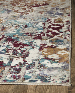 Close-up edge view of an abstract area rug with blue, gold, and white designs.