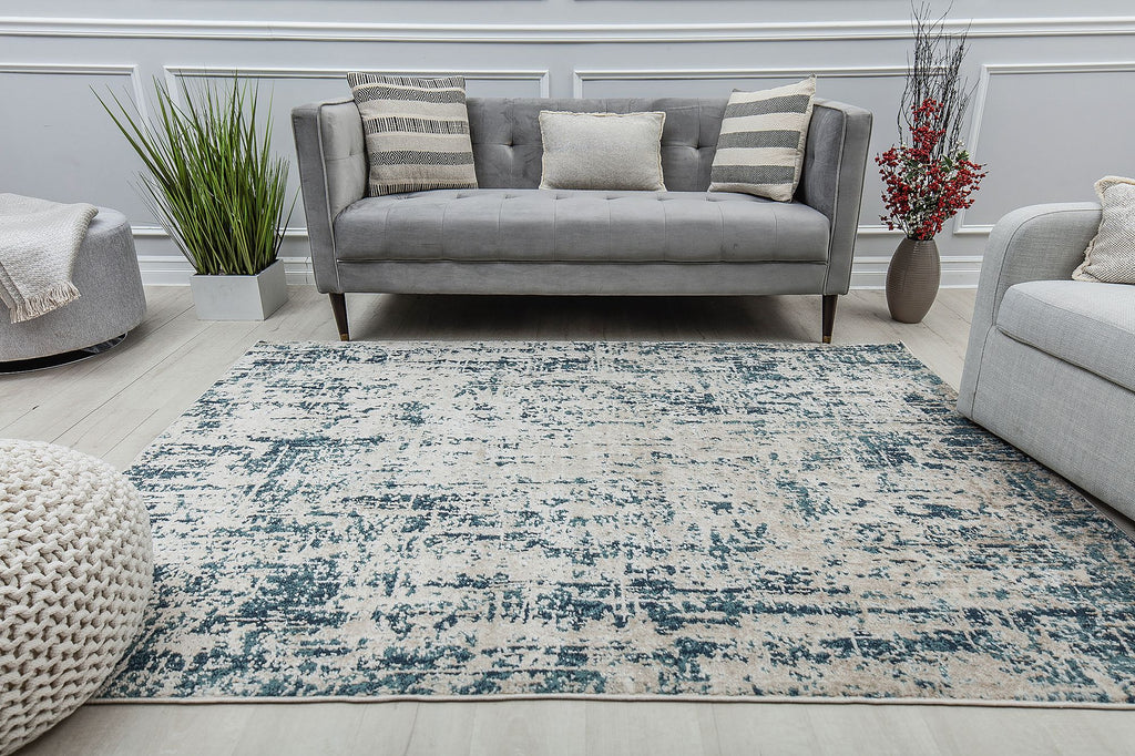 Living room with a modern sofa and a rug featuring a distressed blue and white pattern, enhancing the contemporary decor.