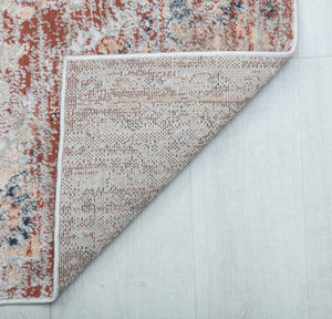 Close-up of the back side of a vintage-style rug, showcasing its durable weave and intricate red and beige distressed pattern.