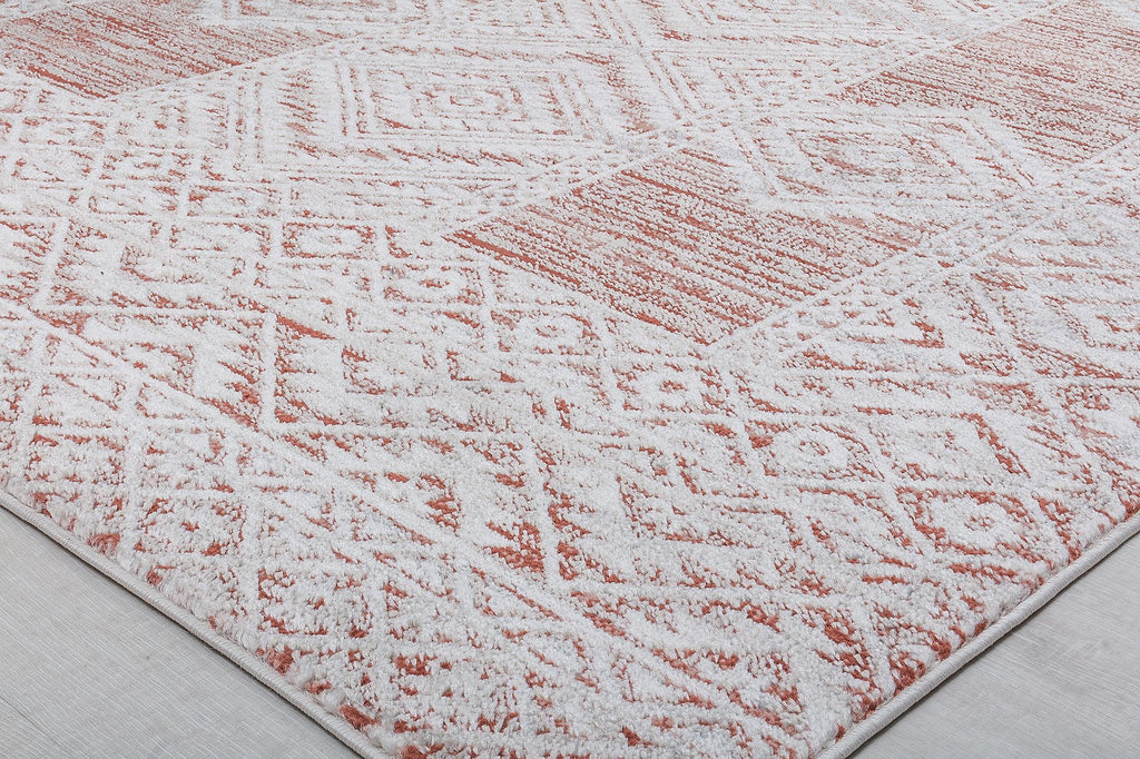 Close-up of the corner of a red and white geometric pattern rug, highlighting intricate design and texture.