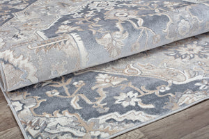 Close-up view of a rolled gray and white traditional pattern rug, showing texture and design details.