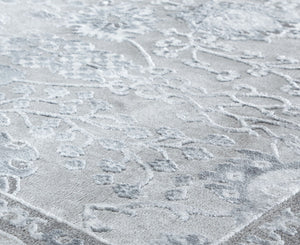 Close-up of a gray area rug showcasing its intricate floral patterns and soft texture, perfect for adding elegance to any room.