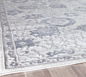 Close-up of the edge of a gray area rug, highlighting its detailed border and floral design, perfect for adding a stylish touch to any space.