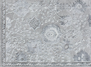 Detailed view of a gray area rug with intricate floral patterns, highlighting its luxurious texture and design.