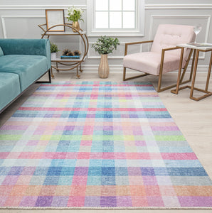 Colorful checkered rug with pastel shades, set in a modern living room featuring a teal sofa, beige armchair, and decor accents.