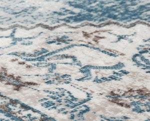 Close-up of a blue and gray distressed rug, highlighting its intricate patterns and textured surface for a vintage appeal.