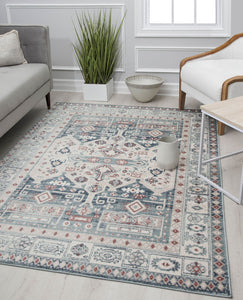 Chic living room with a white and blue patterned rug, modern furniture, and green plant decor, creating a serene and stylish atmosphere