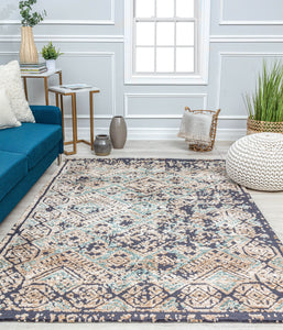 Stylish living room with a blue sofa, modern furniture, and a large patterned rug, adding an elegant touch to the interior decor