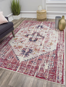 Contemporary living room with a red and white bohemian rug, dark sofa, green plant, wicker basket, and gold vase accents