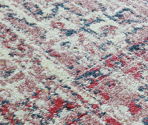 Close-up view of the texture and colors of an antique rose area rug.