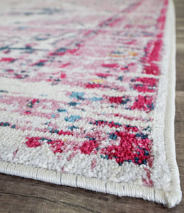 Side view of an antique rose area rug, highlighting the detailed border patterns.