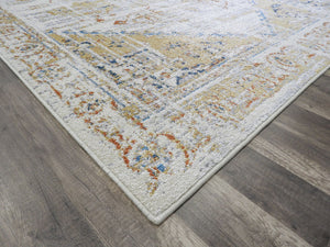 Corner view of a Tuscan sun area rug with intricate patterns on a wooden floor.