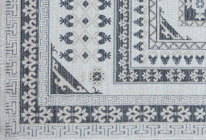 Detailed close-up of intricate patterns on a white and grey area rug.