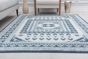 Blue and white geometric patterned rug in a contemporary living room with a sofa and modern decor elements.