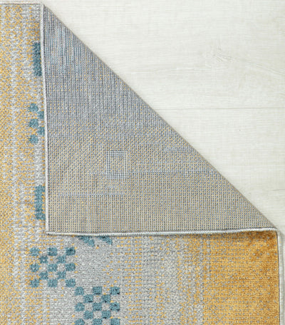 Close-up view of a reversible rug corner showing durable backing and intricate blue and beige pattern, ideal for versatile home decor.