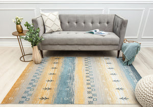 Living room with a modern sofa and a colorful rug featuring blue and beige geometric patterns, adding warmth and style to the space.