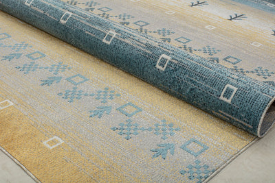 Rolled-up rug showcasing its intricate blue and beige geometric patterns, highlighting durability and style for home decor.