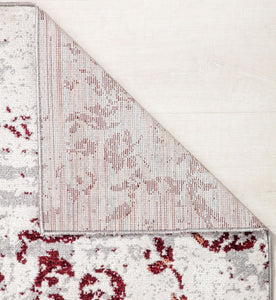 Close-up view of a rug corner showing durable backing and vintage red floral patterns on a beige background, ideal for classic decor