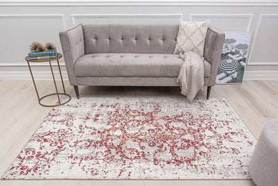 Living room with a modern sofa and a vintage-style rug featuring intricate red floral patterns on a beige background, enhancing classic decor.