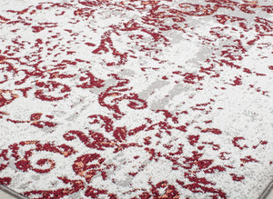 Detailed view of a vintage-style rug with intricate red floral patterns on a beige background, perfect for adding elegance to any decor.