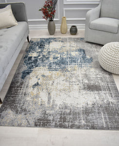 Modern abstract rug in a living room with a grey sofa, decorative vases, and a pouf on a white floor