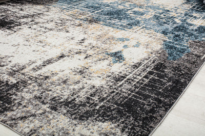 Close-up of a rug with a distressed blue and beige pattern, highlighting its detailed design and texture for modern interiors.