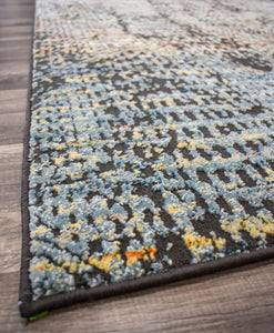 Side view of an abstract rug with intricate blue and yellow patterns, highlighting the texture and design.