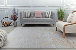 Contemporary living room with minimalist beige area rug, gray sofa, and wooden accent chair, enhancing the room's modern aesthetic.