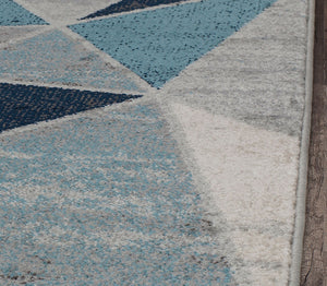 Close-up of blue and white geometric rug with triangular patterns.