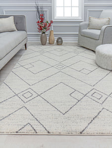 Modern living room with a geometric patterned rug, grey sofa, beige armchair, round ottoman, and decorative vases on the floor