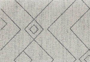 Close-up of gray rug with diamond and geometric patterns, highlighting the detailed design and soft texture, perfect for modern spaces.