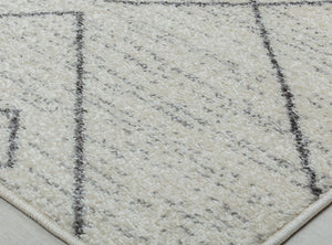 Close-up of the cream rug corner with geometric lines, showcasing the texture and intricate design for modern interiors.