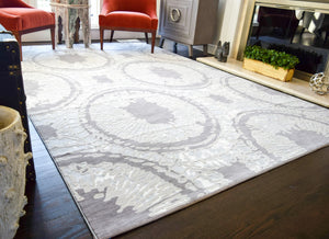 Boho grey area rug with circular abstract patterns in a modern living room setting.