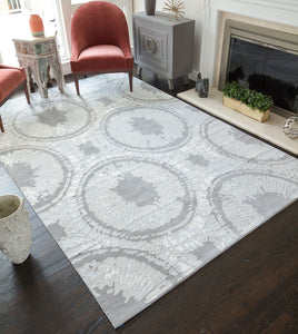 Stylish living room with an abstract patterned rug, red velvet chairs, a side table, and a fireplace creating a cozy ambiance