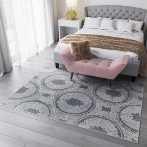 Boho grey area rug with circular abstract patterns in a modern bedroom setting.