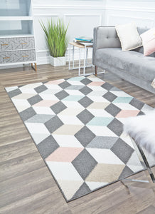 Geometric rug with 3D cube patterns in grey, pink, and blue, placed in a bright, modern living room. Enhances contemporary interior design.