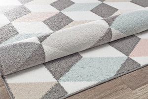 Close-up of geometric rug with 3D cube patterns in grey, pink, and blue, showcasing texture and design. Ideal for modern interiors