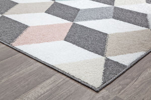 Corner view of geometric rug with 3D cube patterns in grey, pink, and blue on a hardwood floor. Enhances modern interior design.